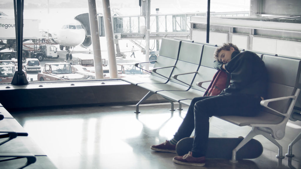 Müder Passagier beim Schlafen auf dem Flughafen