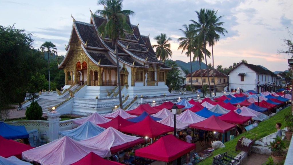 Aussicht auf den Nachtmarkt von Luang Prabang mit dem königlichen Palast im Hintergrund