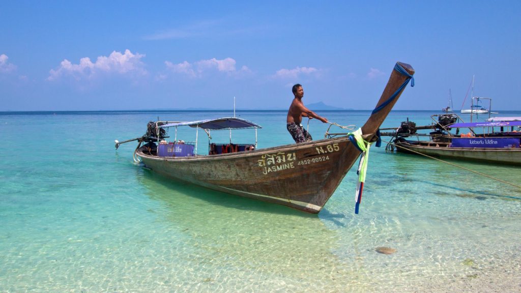 Longtailboot mit Fahrer am Strand von Chicken Island