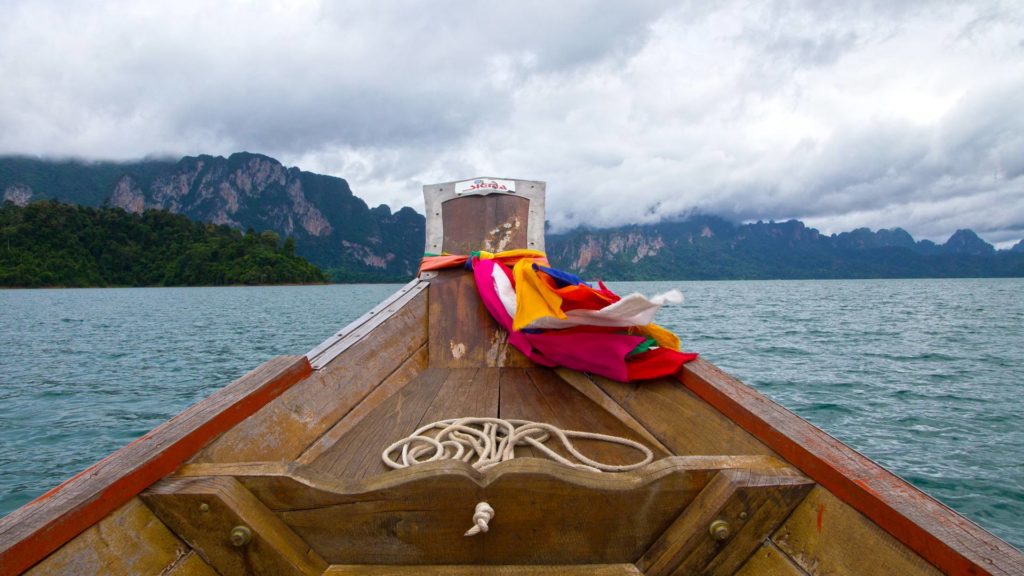 Longtail boat sailing on Cheow Lan Lake in Khao Sok National Park