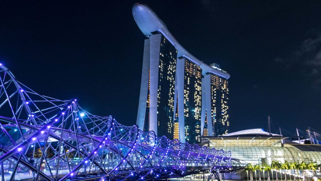 Die Helix Bridge bei Nacht, im Hintergrund das Marina Bay Sands