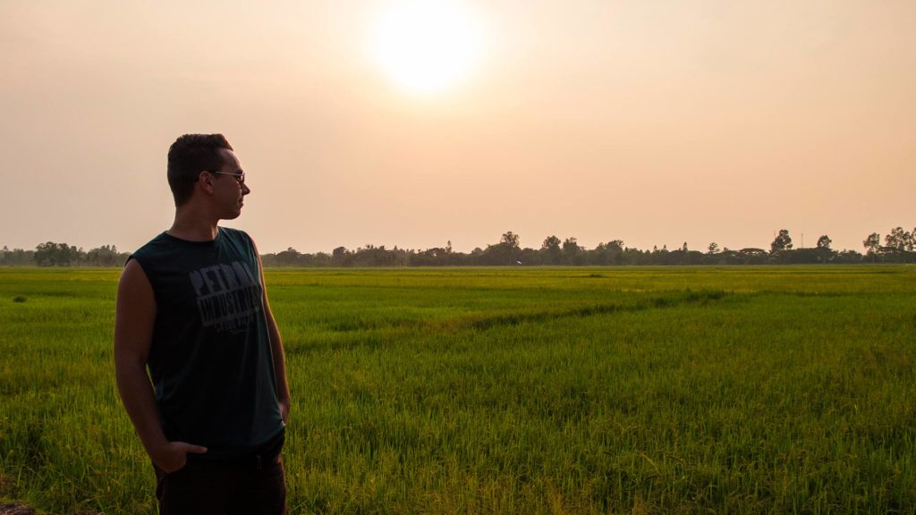 Marcel in einem Reisfeld im Isaan während des Sonnenuntergangs