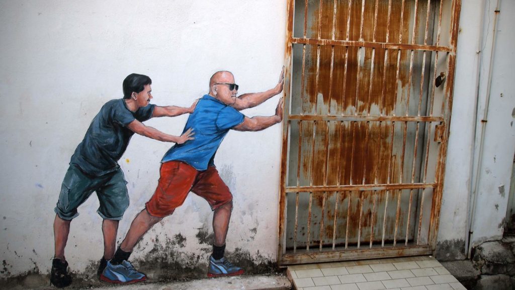 Street Art in George Town, Penang (Männer, die eine Tür zuschieben)