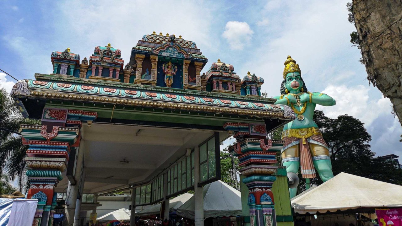 Statue of the Hindu god Hanuman and the entrance to the Batu Caves train station