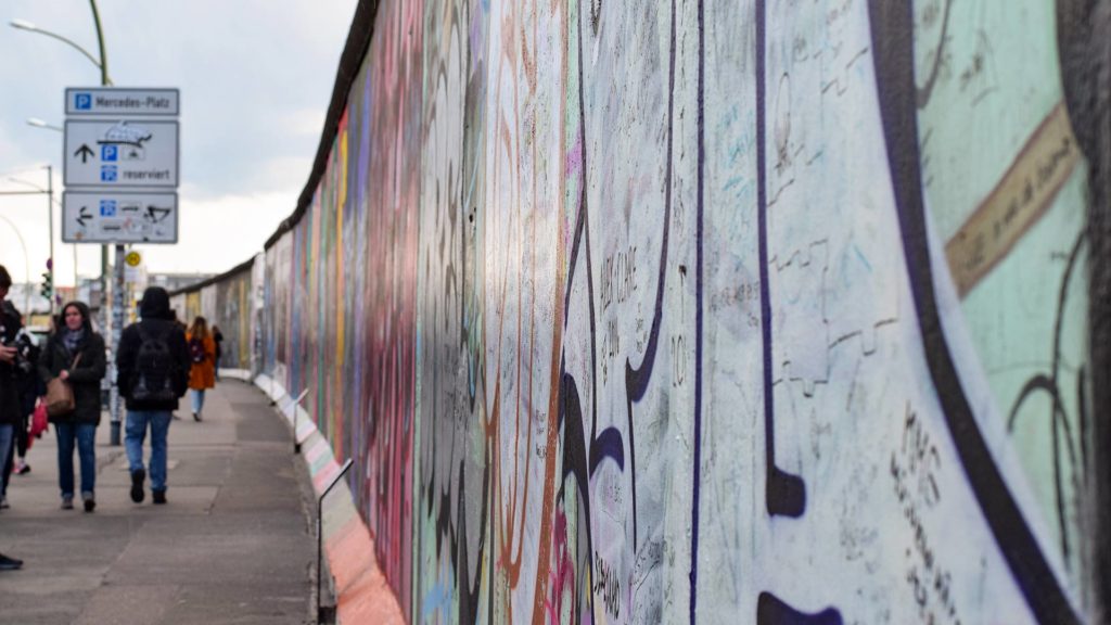 Fußgänger an der East Side Gallery in Berlin