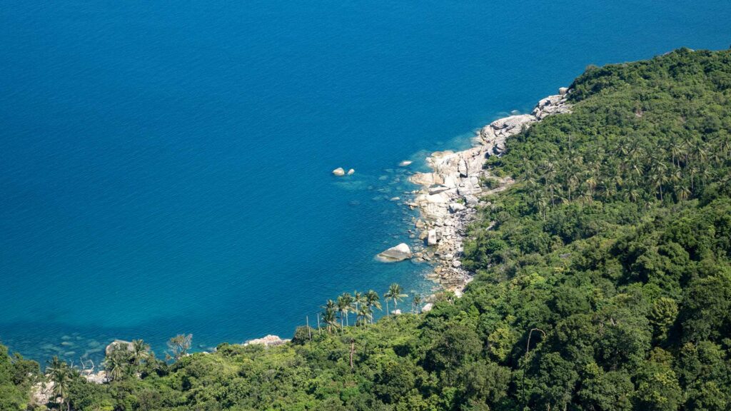 Aussicht auf das Meer und die grüne Berglandschaft Koh Phangans vom Bottle Beach Viewpoint