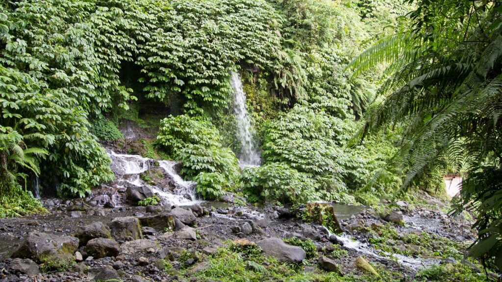 Am Fuße des Benang Kelambu Wasserfalls bei einer Tropenwanderung in Lombok, Indonesien