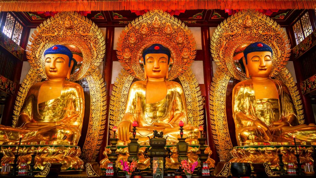Three golden Buddha statues in the Six Banyan Trees in Guangzhou, China
