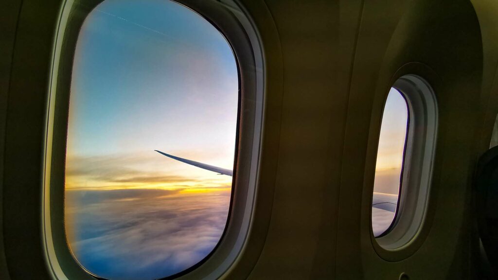 Aussicht aus dem Flugzeug-Fenster beim Sonnenuntergang